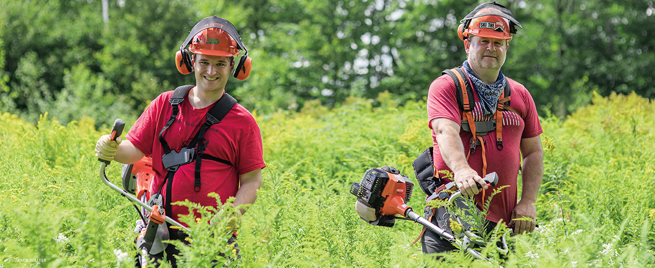 Jon Palmer (left) and Jeff Marcoux (right) pause for a break amongst the waist-high undergrowth they set out to clear on a humid August morning in Maine. Jon, who was participating in his first volunteer glade day, quickly learned the ropes of operating a brush saw from Jeff—an invaluable tool that they use to tackle 90 percent of their maintenance.